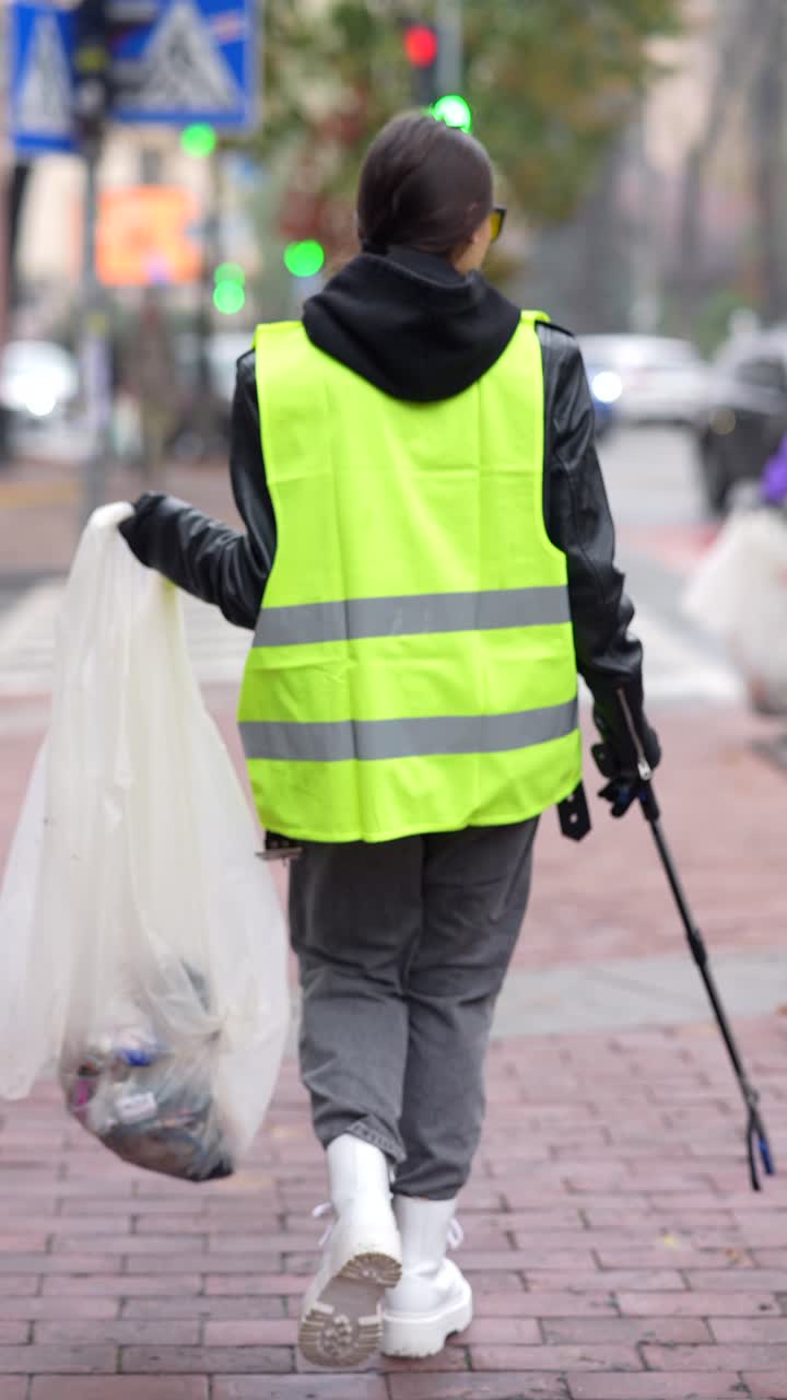 mujer limpiando la basura en la calle de la ciudad