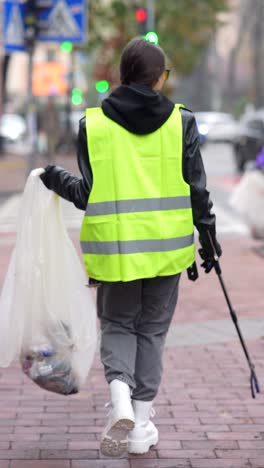 woman cleaning up trash on city street