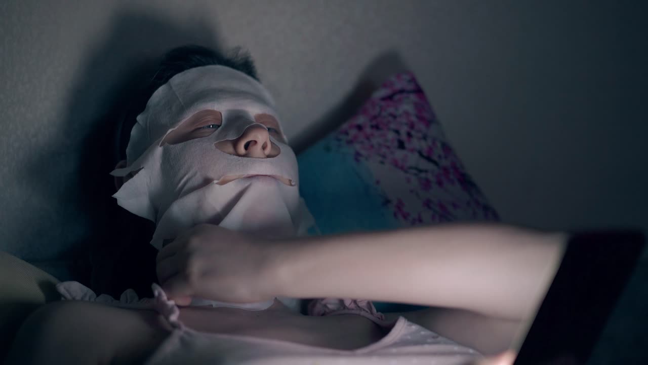 una morena con una camiseta rosa coloca una máscara especial en la cara