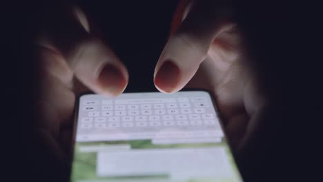 hands typing on smartphone at night