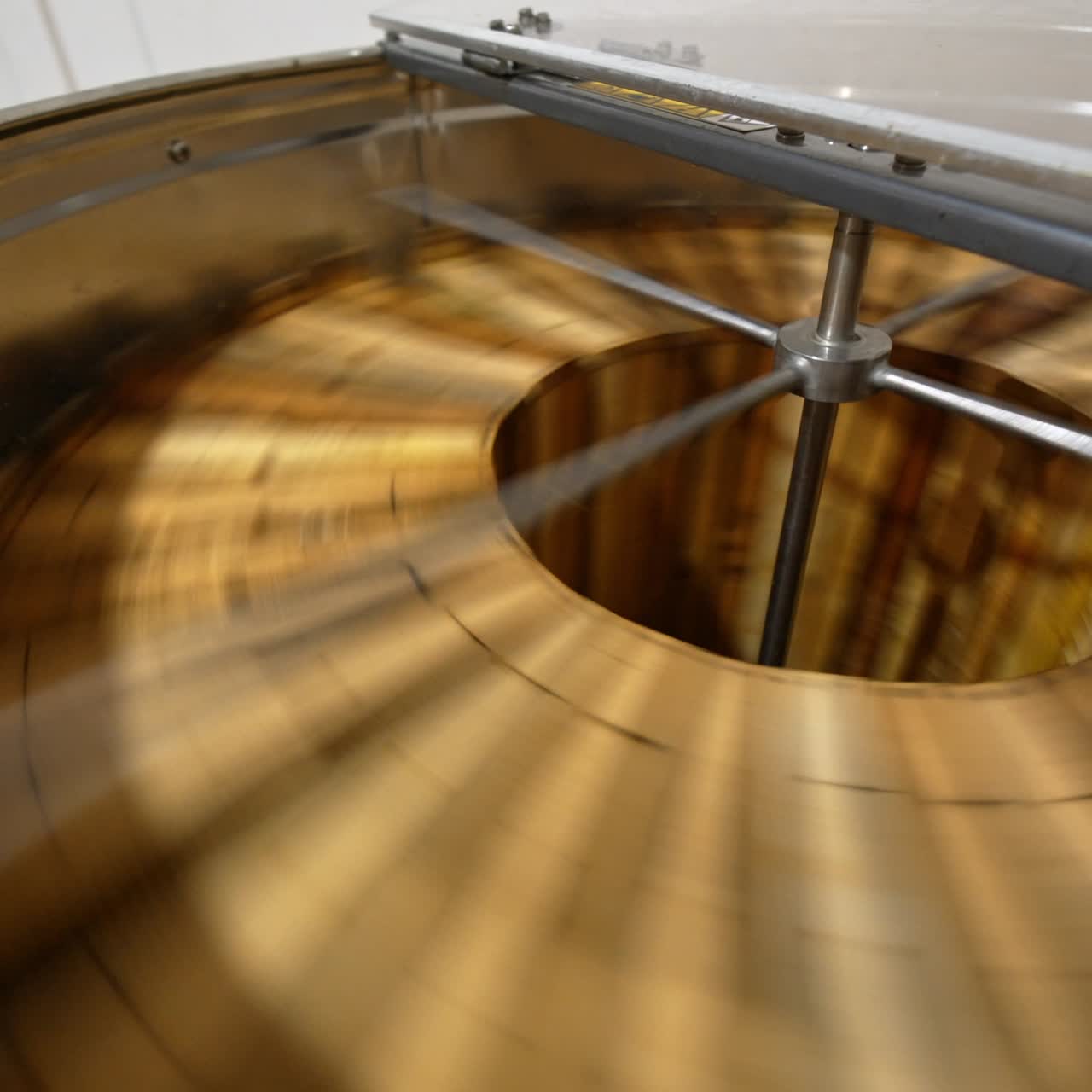 Working machine for extraction of honey at apiary. Centrifuge apparatus rotates multiple wooden frames to remove honey. Top view