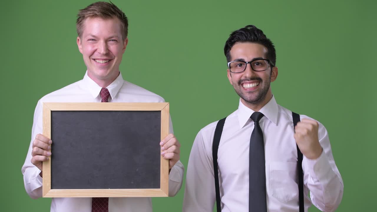 dos jóvenes empresarios multiétnicos trabajando juntos contra un fondo verde