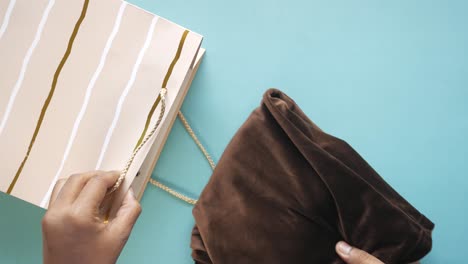 men taking a cloth out from a shopping bag