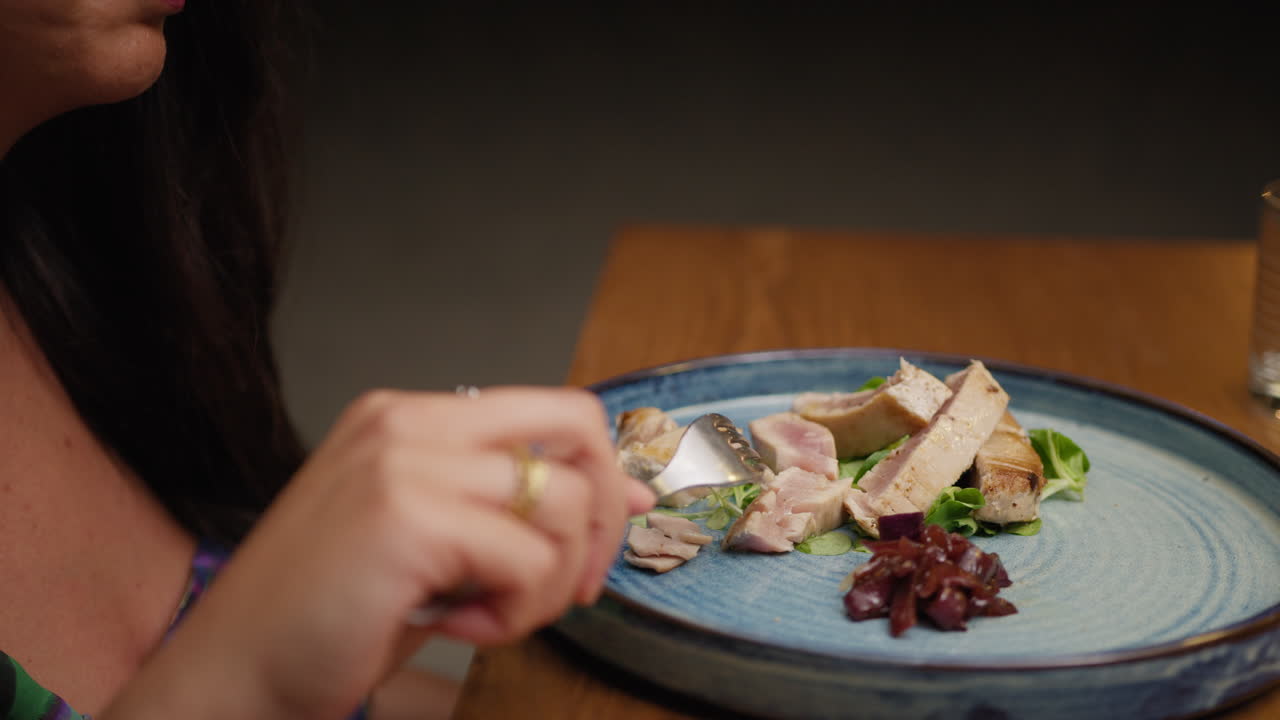 Woman Using The Fork To Cut Pieces Of The Tuna For Dinner