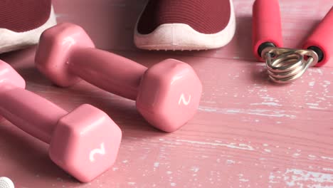 pink dumbbells, hand grips, and running shoes