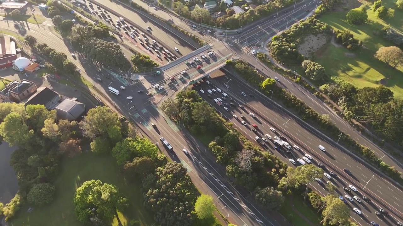 Vista aerea con drone del traffico autostradale mattutino e di un cavalcavia sulla Northwestern Motorway ad Auckland, Nuova Zelanda.