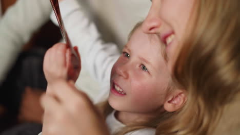 daughter looks at family shoots on film with young mother