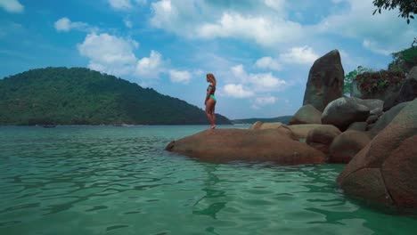 un hermoso cinemagraph 4k uhd de una playa tropical junto al mar en la isla perhentian, malasia y una mujer morena en la playa