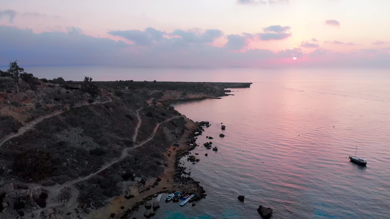 un dron aéreo disparó sobre la bahía de konnos al atardecer con un brillo violeta rosado