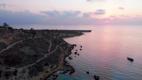 aerial drone shot over konnos bay at dusk with a pink purple glow