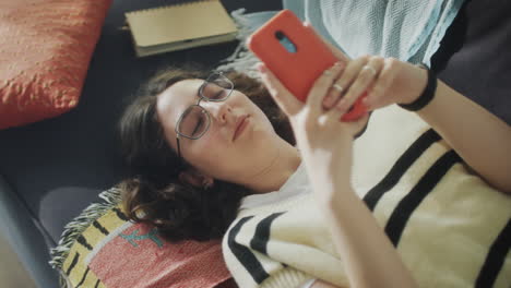 girl resting on couch with phone