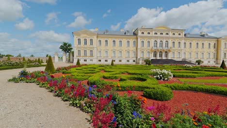 Ornate Baroque palace and vibrant garden unfold in slow motion panoramic shot