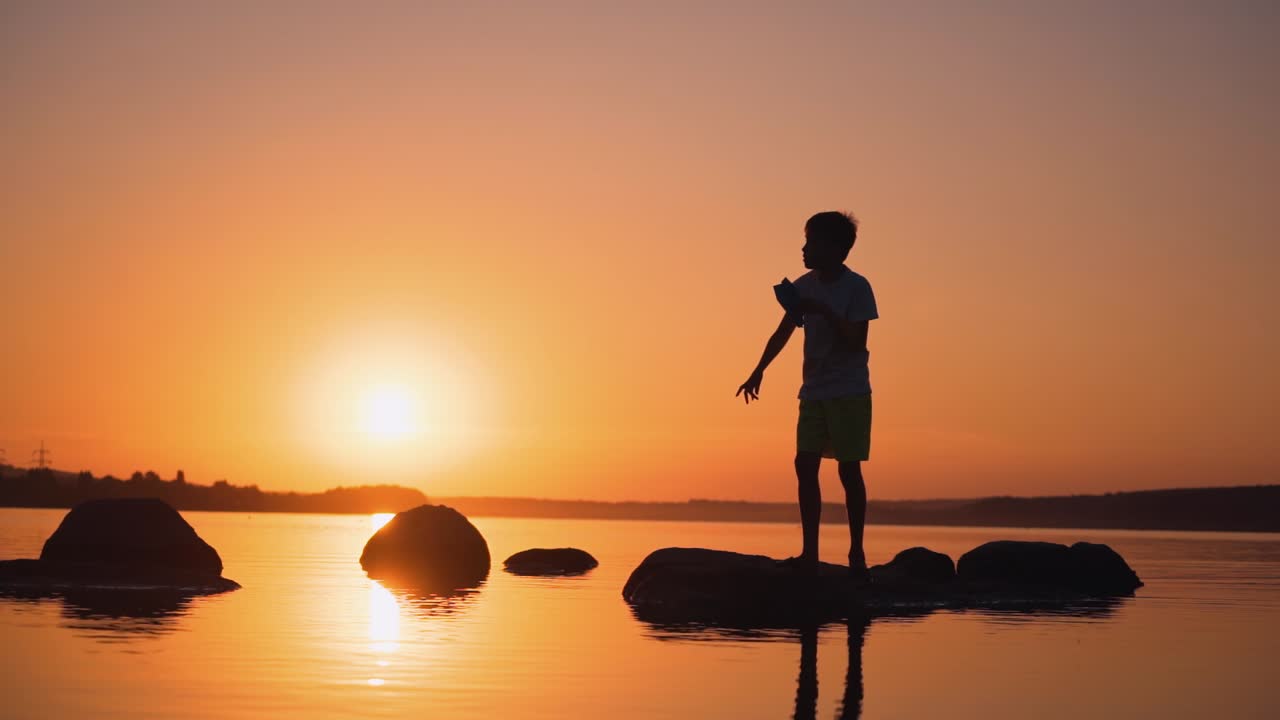 Teenager near the river. Adorable kid playing with paper plane near river