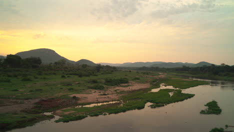 puesta de sol en el parque nacional kruger en el río puerta de entrada sur pájaros flamenco cocodrilo debajo lluvioso primavera verde exuberante impresionante paisaje montañoso dorado amarillo naranja panorámica cinematográfica hacia abajo