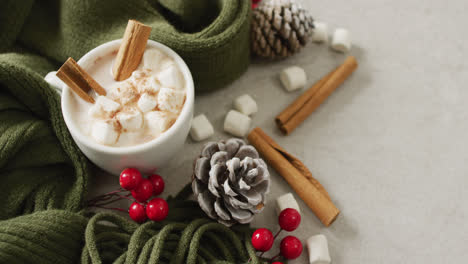 video of cup of hot chocolate with marshmallows and warm blanket over grey background