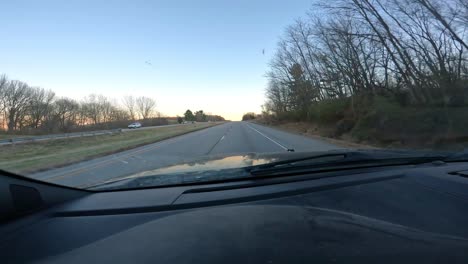 point of view through the front window while driving on a interstate with little traffic