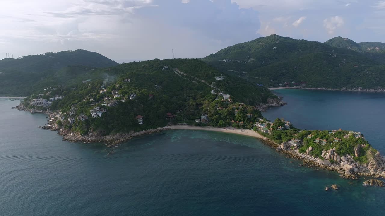 vista aérea de una isla tropical con playa de arena blanca, vegetación exuberante y agua azul