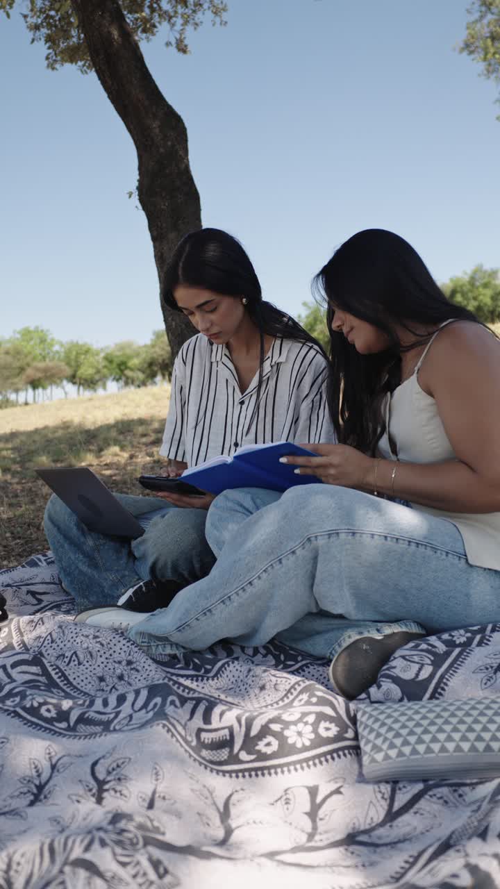 Dos mujeres estudiando al aire libre en un parque