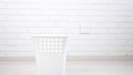 person disposing of a cloth in a laundry basket