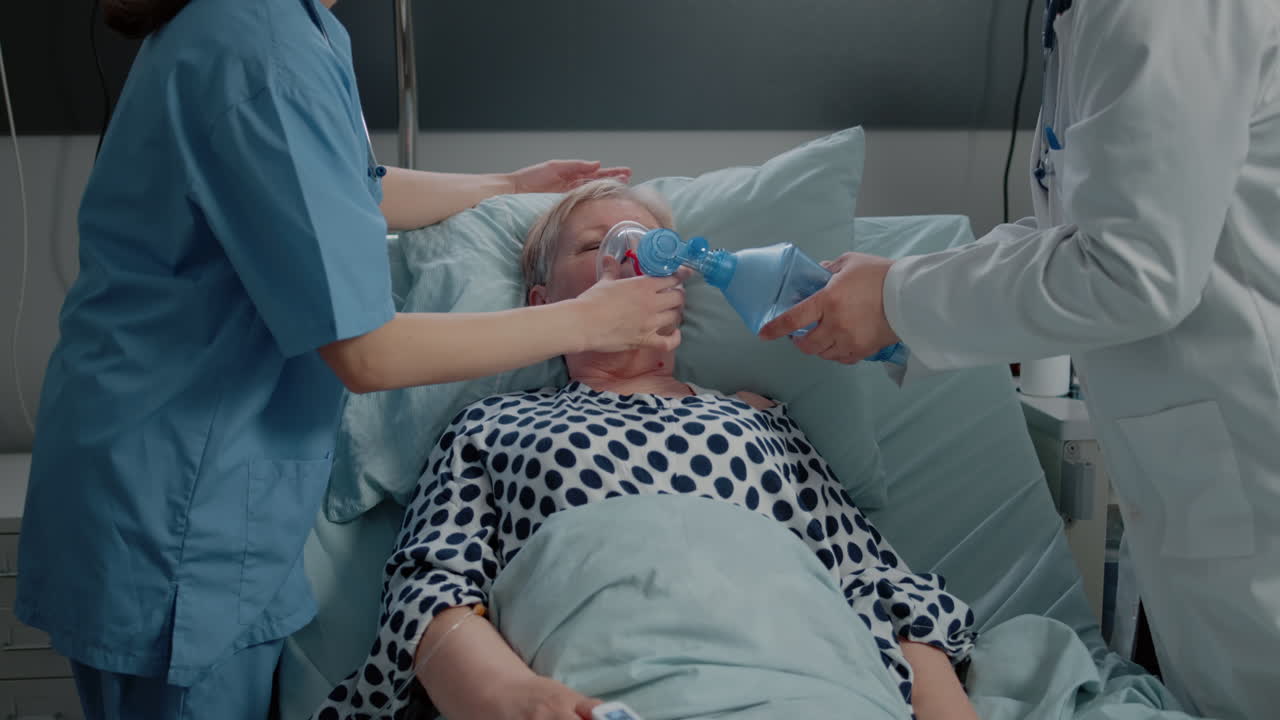 Doctor and nurse using oxygen tube for hyperventilating woman