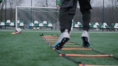 a children's football team trains at the stadium under the guidance of a coach. kids in sports uniforms practice ball exercises, improve technique, and develop teamwork on the green field