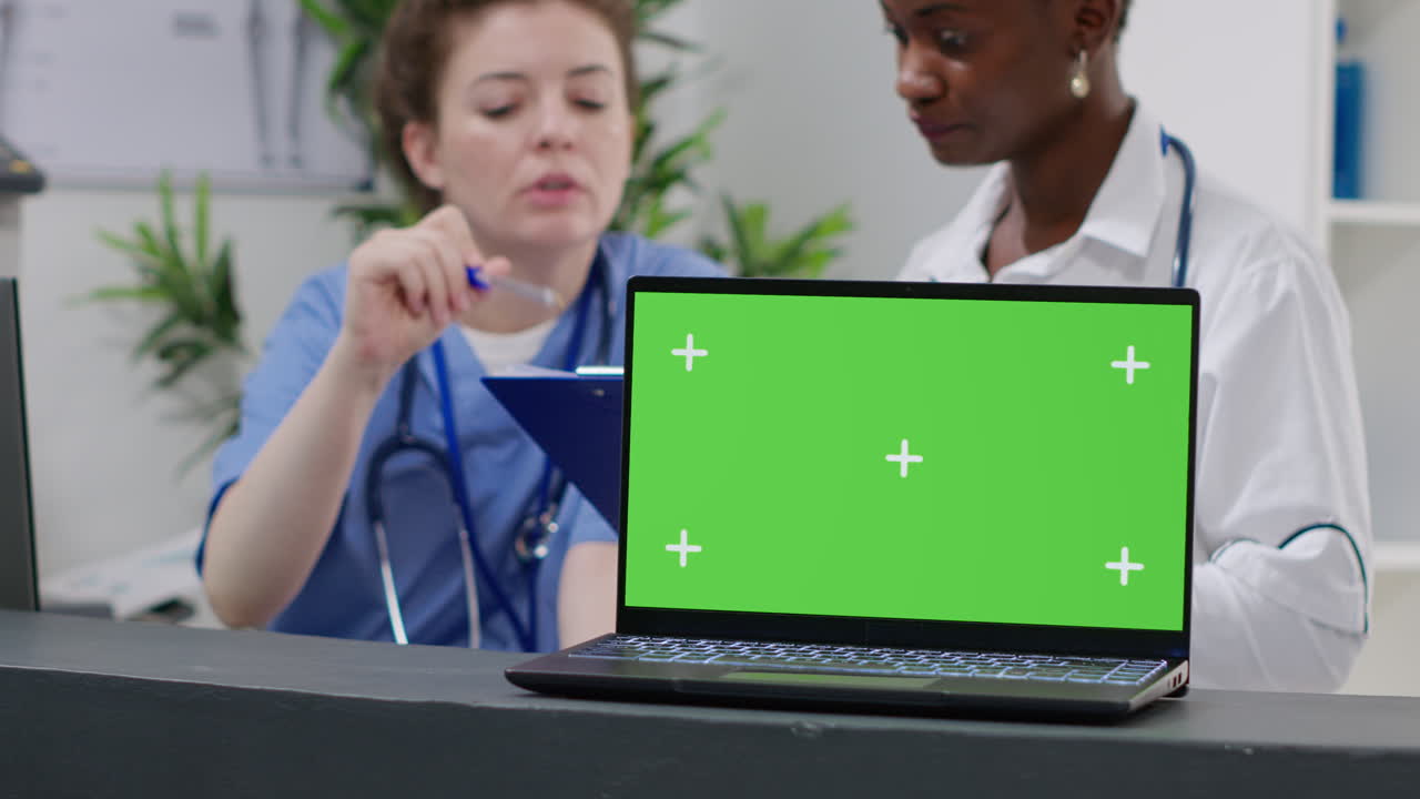 Medical professionals with a green screen laptop