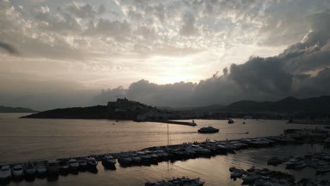 드론은 ibiza, 스페인에서 배경에 어두운 구름과 함께 항구 위를 날고 있습니다.