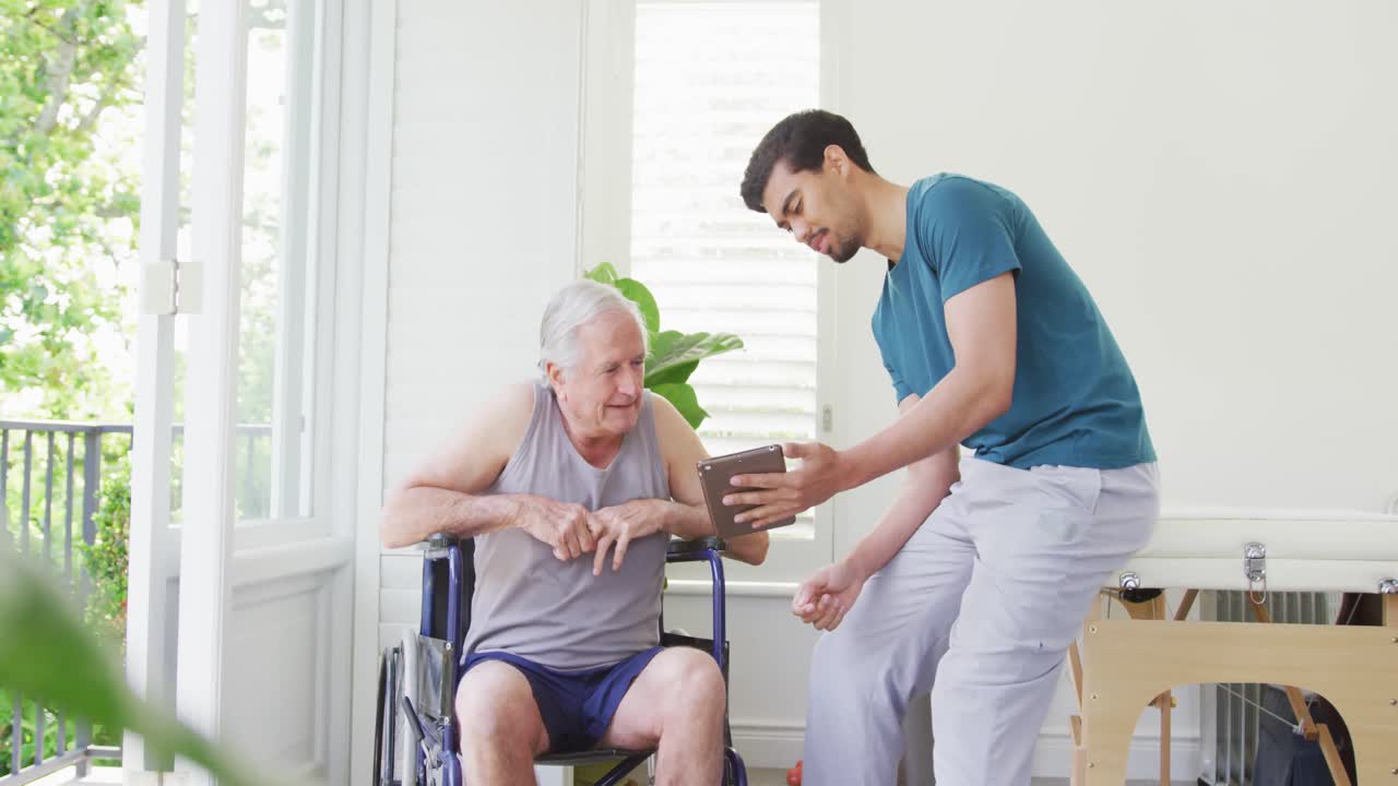 남성 피트니스 코치 가 헬스 클럽 에서  ⁇ 체어 를 타고 있는 장애인 노인 과 토론 하고 있다