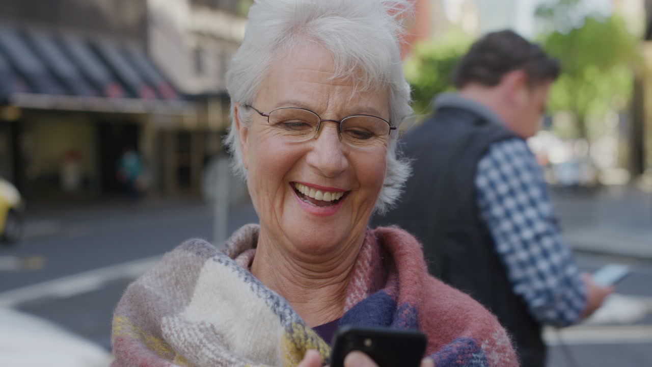 retrato de una mujer anciana usando un teléfono inteligente enviando mensajes de texto disfrutando de la navegación en línea enviando mensajes en la tecnología de teléfonos móviles sonriendo feliz en la calle de la ciudad serie de personas reales