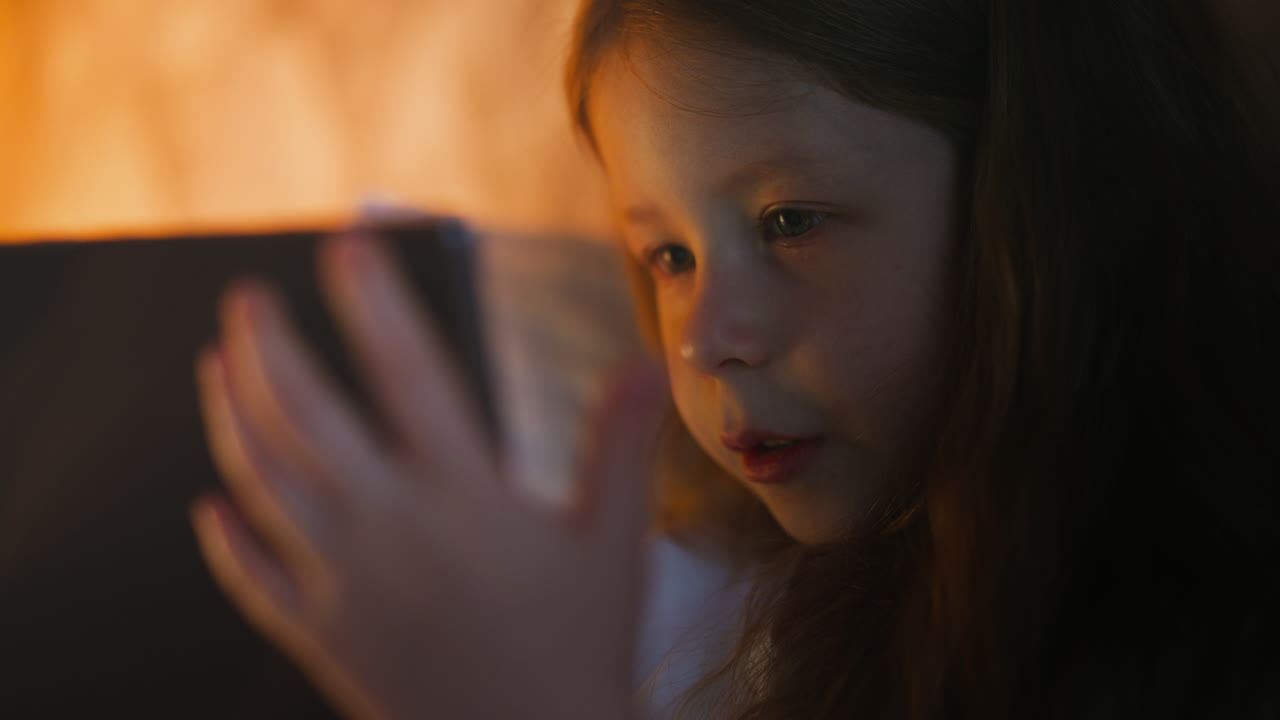 작은 아이 가 침대 에 누워 있는 태블릿 을 통해 비디오 통화 를 하고 있다