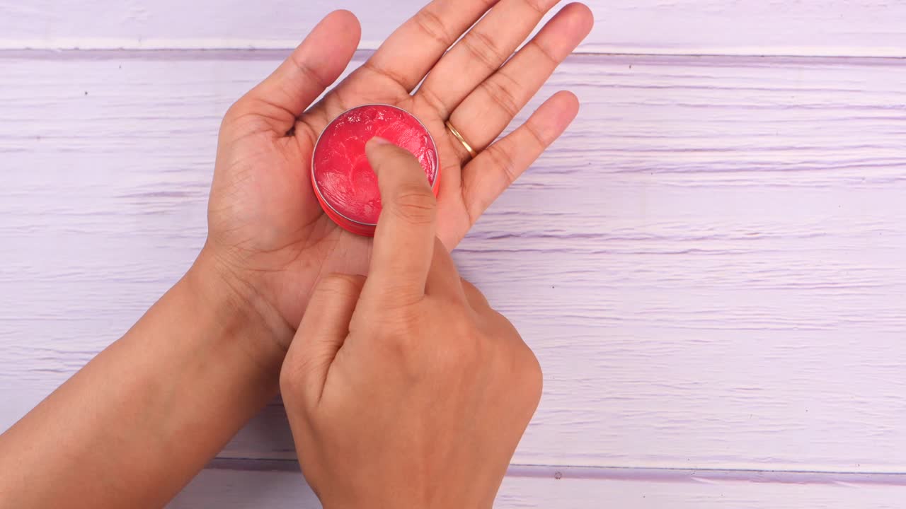 aplicación de bálsamo para los labios en las manos