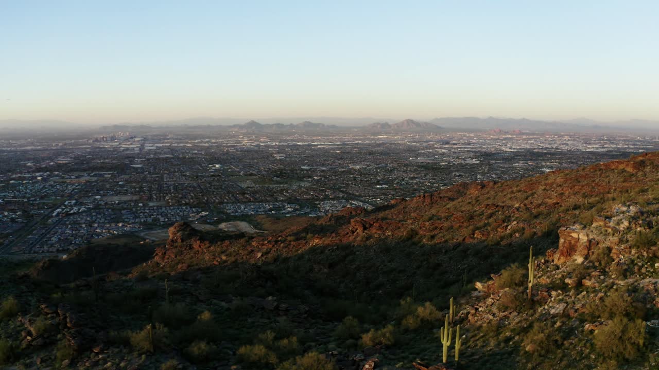 Drone shot of sprawling neighborhoods in Phoenix, Arizona surrounded by mountains
