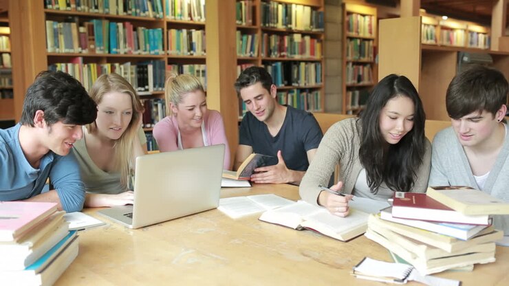 Gruppo di studenti che studia in una biblioteca
