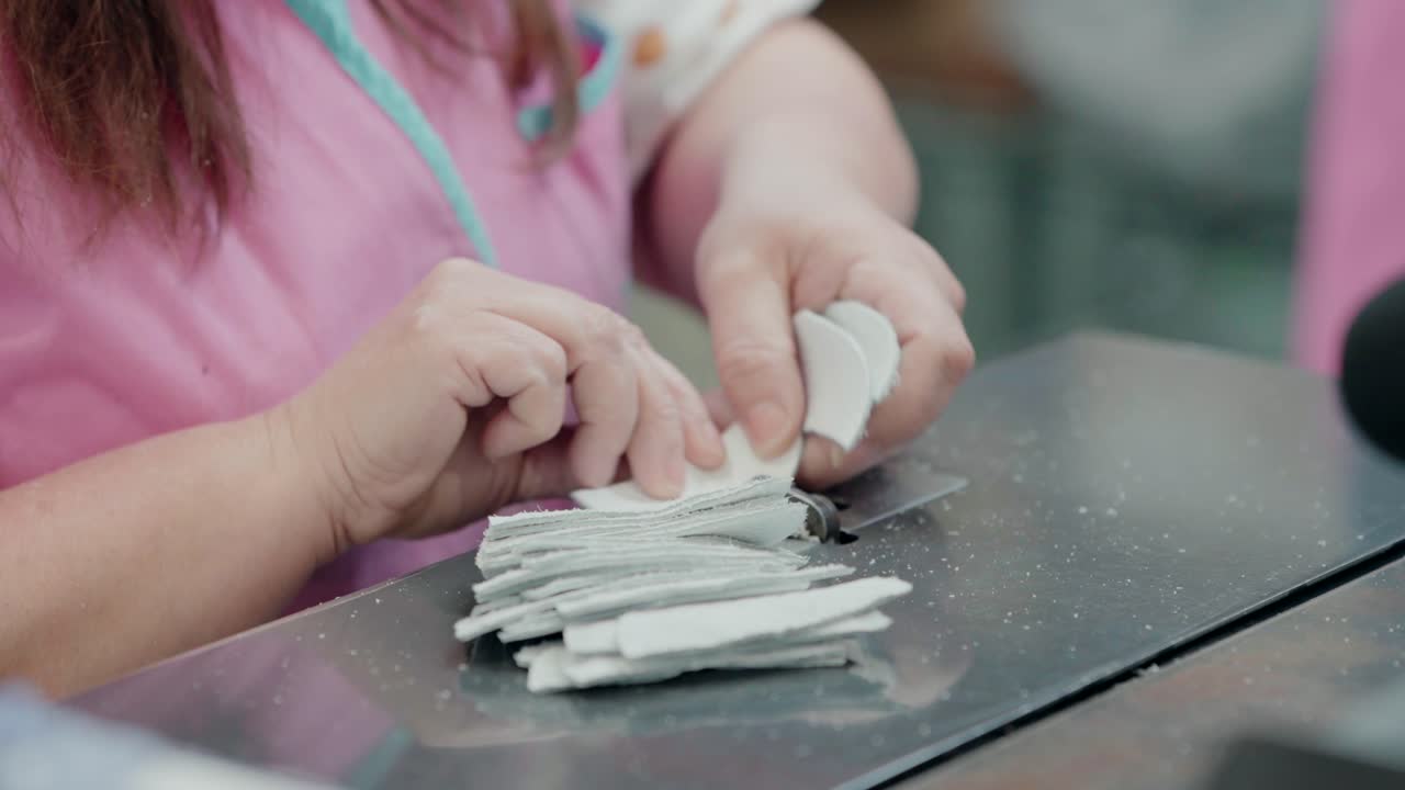 trabajador cortando piezas de cuero para la fabricación de zapatos en la fábrica, primer plano de manos y materiales
