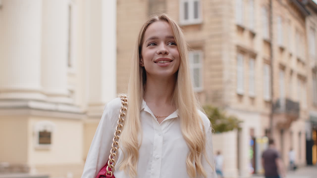 Portrait of young woman girl tourist walking in urban city street smiling having positive good mood