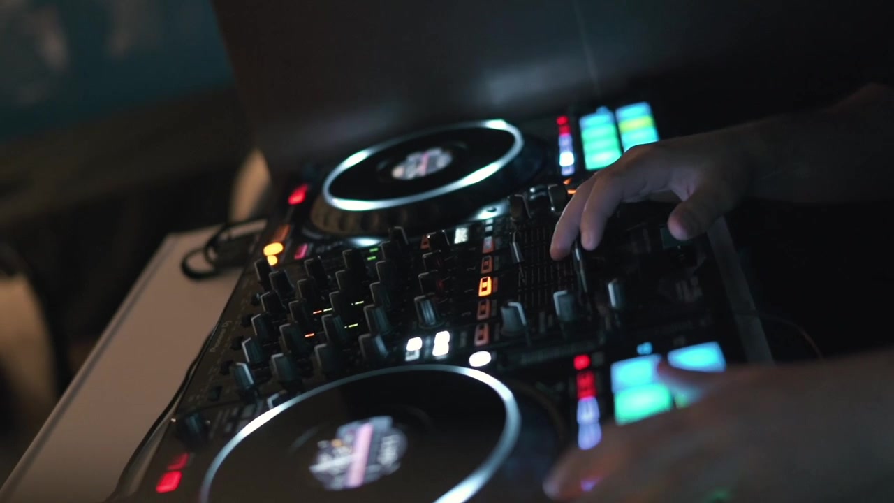 Mixer DJ Controller: Vista Ravvicinata delle Mani che Azionano i Pulsanti durante una Performance Musicale Notturna