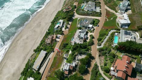 paragliding flight over houses by the sea on the coast of chile