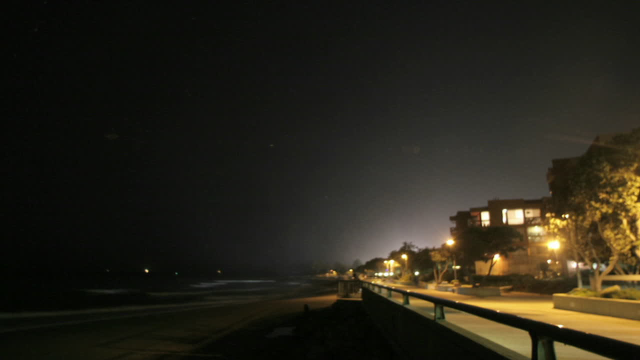 los fuegos artificiales explotan en una playa en un lapso de tiempo