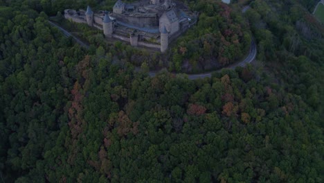 Castillo-De-Bourscheid-En-La-Cima-De-La-Colina-Del-Bosque-En-Luxemburgo-En-Un-Día-Gris-Nublado,-Aéreo