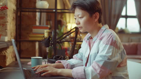 asian woman working on laptop at home