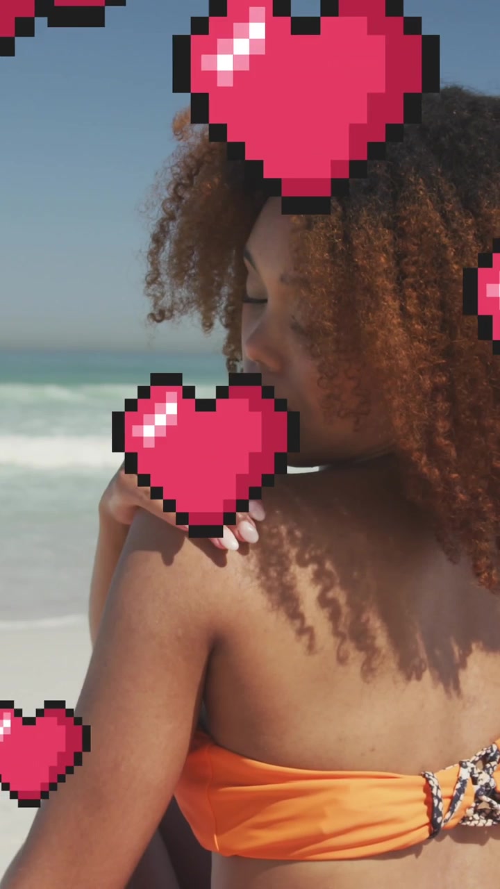 Animazione di icone digitali a forma di cuore su una donna che applica la crema solare in spiaggia