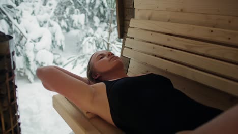 mujer caucásica disfrutando en la sauna en invierno