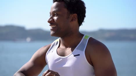 Happy-african-american-sportsman-jogging-at-riverside