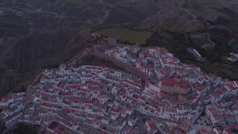 Revelar-Toma-De-La-Ciudad-Histórica-De-Pisticci-En-La-Cima-De-La-Colina-Durante-La-Puesta-De-Sol,-Antena