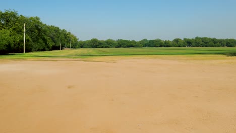 isolated green playing ground with bright blue sky at day from flat angle