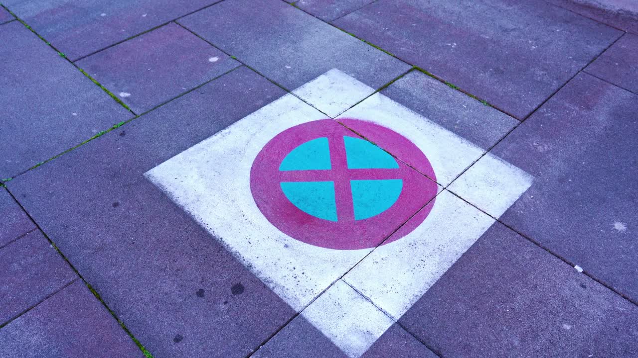 carretera de asfalto con gran cuadrado pintado y círculo rojo cruzado