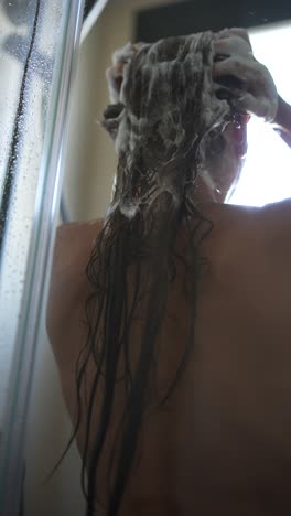 mujer lavando el cabello en la ducha