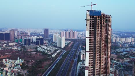 under construction tallest building at financial district, nanakramguda, hyderabad, telangana, india. day time, closeup, semi orbit, drone shot, 4k.