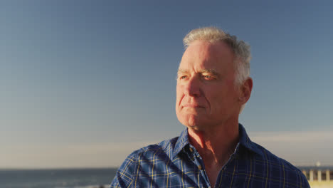 side view of senior man in front of beach