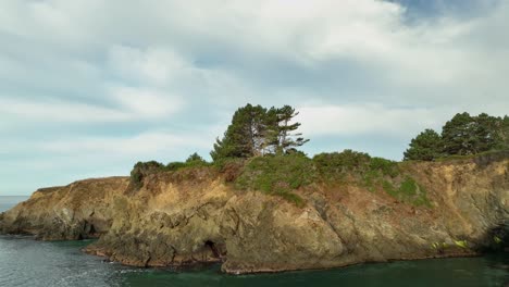 Wide-aerial-view-of-rocky-cliffs-overlooking-the-ocean-on-an-overcast-day